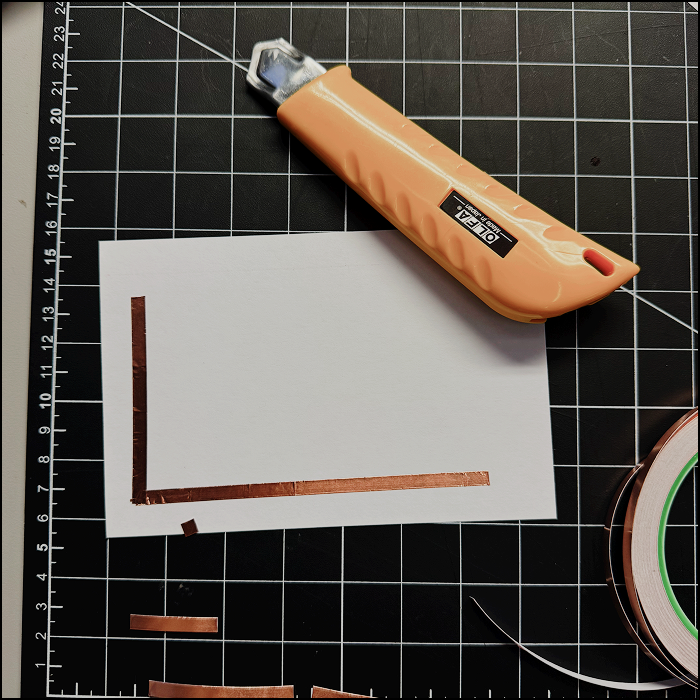 Image shows me measuring and cutting the copper tape to build the circuit