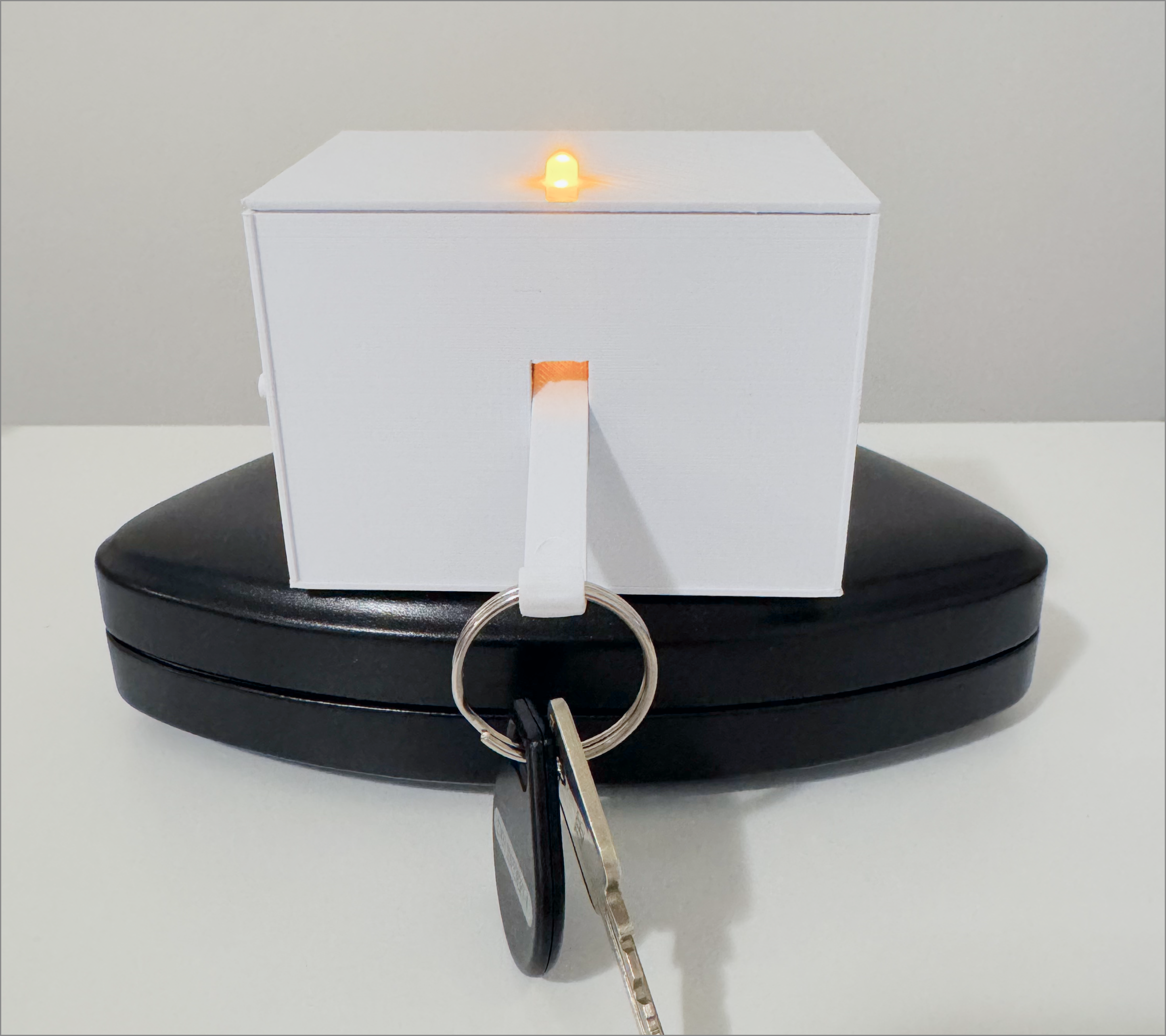 The light is triggered when a weighted object is hooked onto the hinge, for instance keys or other small items. Visible light bulb on the object indicates a specific interaction needs to be performed to trigger a response.